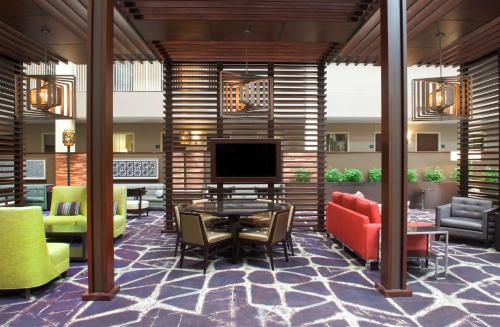 a lobby with a table and chairs and a television at Embassy Suites by Hilton Philadelphia Airport in Philadelphia