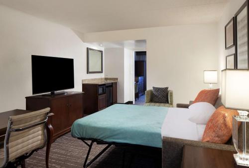 a hotel room with a bed and a flat screen tv at Embassy Suites by Hilton Philadelphia Airport in Philadelphia