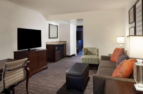 a living room with a couch and a flat screen tv at Embassy Suites by Hilton Philadelphia Airport in Philadelphia