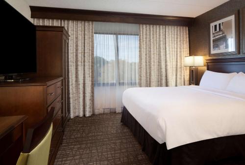 a hotel room with a bed and a large window at Embassy Suites by Hilton Philadelphia Airport in Philadelphia