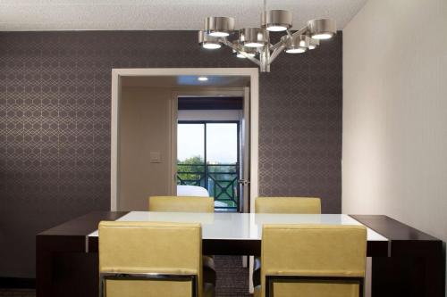 a dining room with a table and yellow chairs at Embassy Suites by Hilton Philadelphia Airport in Philadelphia