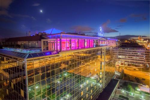 布拉格的住宿－布拉格希爾頓酒店，一座晚上在上面有紫色灯的建筑