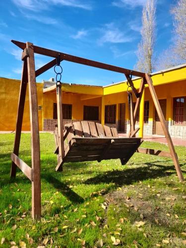 a swing in front of a yellow building at Fatme Hotel in San Agustín de Valle Fértil