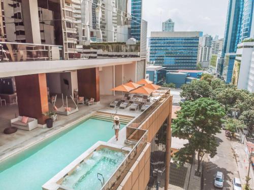 a woman standing on the balcony of a building with a swimming pool at Waldorf Astoria Panama in Panama City