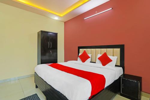 - une chambre avec un grand lit aux murs rouges dans l'établissement OYO Flagship Hotel Abhinandan, à Kanpur
