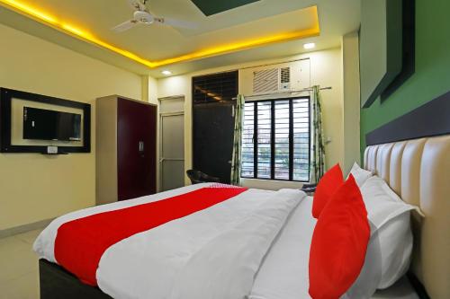 - une chambre avec un lit doté d'oreillers rouges et blancs dans l'établissement OYO Flagship Hotel Abhinandan, à Kanpur