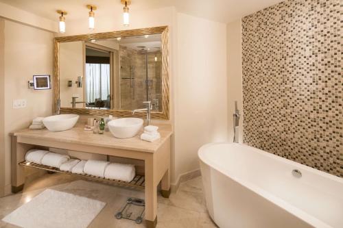 a bathroom with two sinks and a tub and a mirror at Waldorf Astoria Panama in Panama City