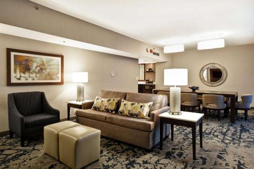 a living room with a couch and a table and chairs at Embassy Suites by Hilton Raleigh Durham Research Triangle in Cary