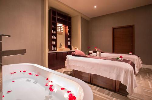 a bathroom with a bath tub and a bed at Waldorf Astoria Panama in Panama City
