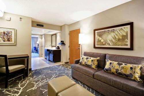 a living room with a couch and a desk at Embassy Suites by Hilton Raleigh Durham Research Triangle in Cary