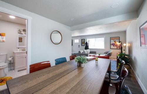 una sala de estar con una gran mesa de madera y sillas en The Yellow Door Denver - Mid Century Design, Game Room, and Wood Spa - Near Downtown Denver, en Denver