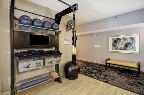 a room with a loft bed with a tv and a bench at Embassy Suites by Hilton Raleigh Durham Research Triangle in Cary