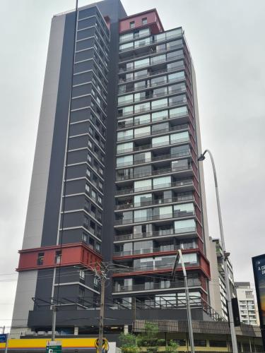 ein hohes Gebäude mit rot und grau in der Unterkunft C1 Estúdio VN1 - A 400 metros do Allianz Parque in São Paulo