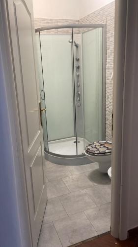 uma casa de banho com um chuveiro, um WC e um espelho. em Appartamento zona centro Savona con due camere em Savona