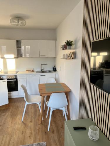uma cozinha com uma mesa e duas cadeiras brancas em Smultron Apartment Altstadt Wismar em Wismar