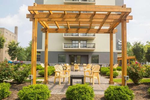 a wooden pergola with a table and chairs in a yard at The Strathallan - a DoubleTree by Hilton in Rochester