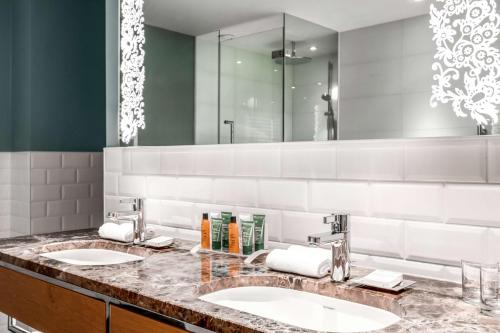 a bathroom with two sinks and a large mirror at Hilton Rotterdam in Rotterdam