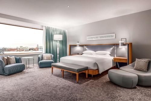 a bedroom with a bed and a large window at Hilton Rotterdam in Rotterdam