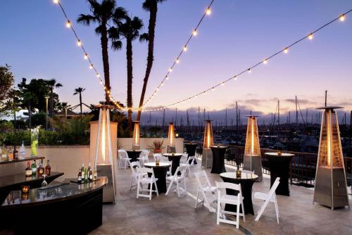 a rooftop patio with tables and chairs and lights at Hilton San Diego Airport/Harbor Island in San Diego