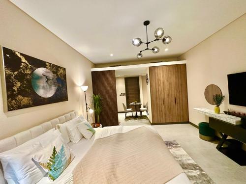 uma sala de estar com uma cama branca e uma secretária em Harbour View Condo - Seaview اطلالة بحرية em Manama
