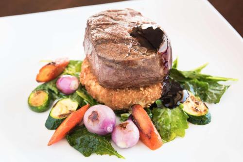 a plate of food with a piece of meat and vegetables at Hilton San Diego Airport/Harbor Island in San Diego