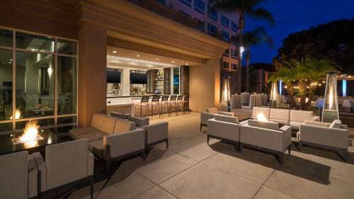 a patio with white chairs and a bar at night at DoubleTree by Hilton San Diego Del Mar in San Diego