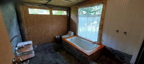 a bathroom with a bath tub and a window at Araplay Lodge in Santa Teresa