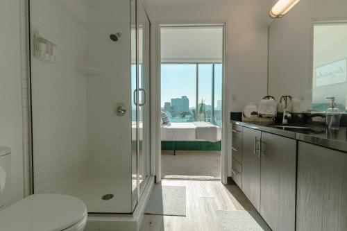 a bathroom with a shower and a toilet and a sink at Modern Luxury 2 Bd Apt with Pool Views and free parking in Los Angeles