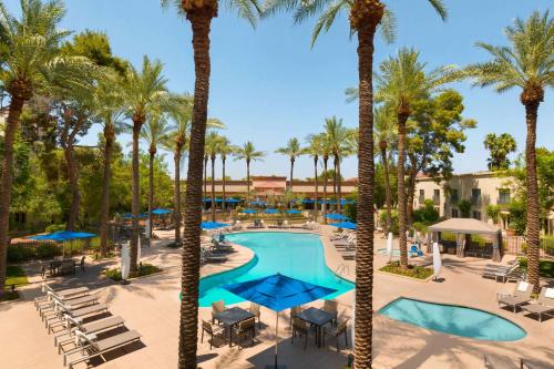 - une vue aérienne sur la piscine du complexe bordée de palmiers dans l'établissement Hilton Scottsdale Resort & Villas, à Scottsdale