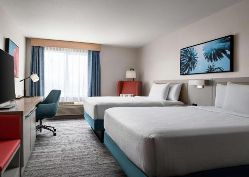 a hotel room with two beds and a television at Hilton Garden Inn San Jose/Milpitas in Milpitas