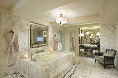 a large bathroom with a tub and a chair at Waldorf Astoria Shanghai on the Bund in Shanghai
