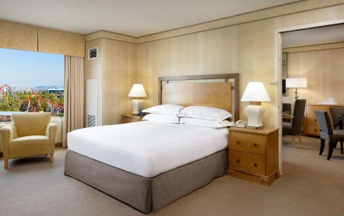 a bedroom with a large bed and a living room at Hilton Santa Clara in Santa Clara