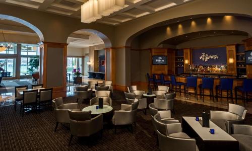 a restaurant with tables and chairs and a bar at Hilton Santa Clara in Santa Clara