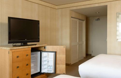 a bedroom with a flat screen tv and a bed at Hilton Santa Clara in Santa Clara