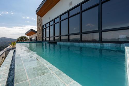 - une piscine d'eau bleue dans un bâtiment dans l'établissement Wanderlust Experience Hotel BW Signature Collection OFICIAL, à Campos do Jordão
