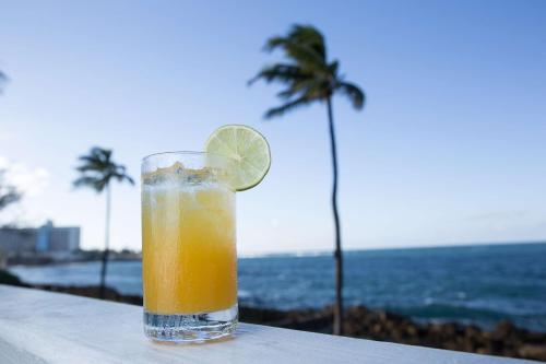 a drink sitting on a table next to the ocean at The Condado Plaza Hotel in San Juan