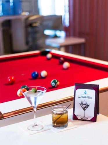 a drink on a table next to a pool table at The Condado Plaza Hotel in San Juan
