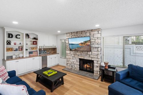 a living room with a fireplace and a tv at 256 Americana in Huntington Beach