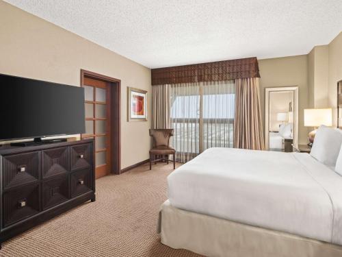 a hotel room with a bed and a flat screen tv at Embassy Suites by Hilton San Marcos Hotel Conference Center in San Marcos