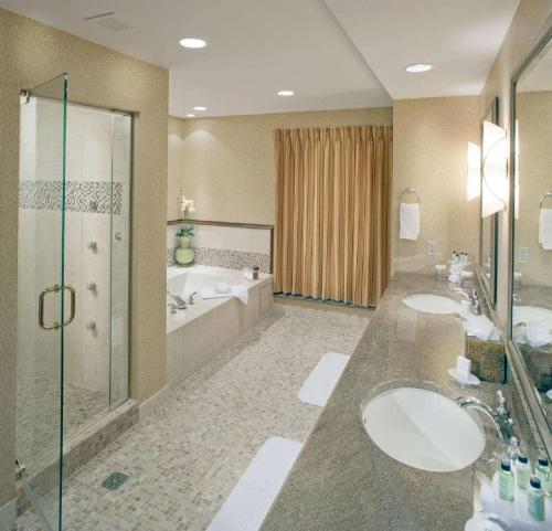 a bathroom with two sinks and a shower and a tub at Embassy Suites by Hilton San Marcos Hotel Conference Center in San Marcos