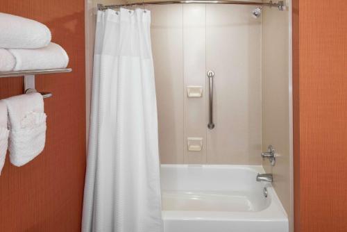 a bathroom with a shower and a white bath tub at Embassy Suites by Hilton Saint Louis Saint Charles in St. Charles