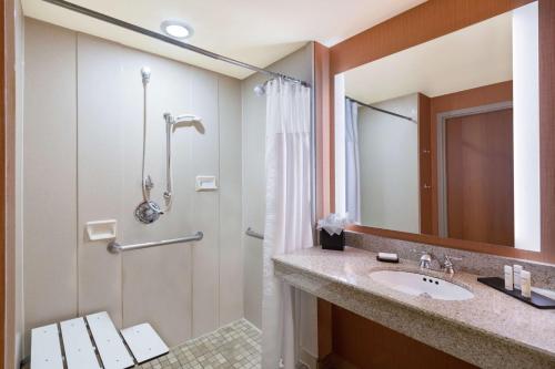 a bathroom with a sink and a shower at Embassy Suites by Hilton Saint Louis Saint Charles in St. Charles