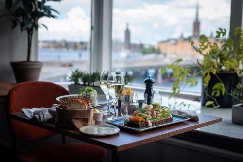 a table with a plate of food and a glass of wine at Hilton Stockholm Slussen Hotel in Stockholm