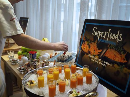 a man preparing a buffet with a tray of food at Hilton Stockholm Slussen Hotel in Stockholm