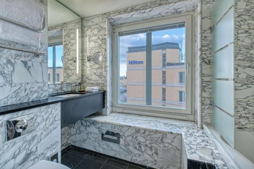 a bathroom with a window and a sink at Hilton Stockholm Slussen Hotel in Stockholm