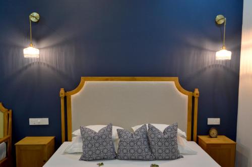 a blue bedroom with a bed with two pillows at Athirige Private Villa in Dharavandhoo