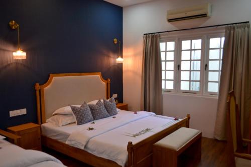a bedroom with a large bed and a window at Athirige Boutique House Dharavandhoo in Dharavandhoo
