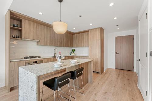 a kitchen with a large island with black bar stools at Level Chicago River North in Chicago