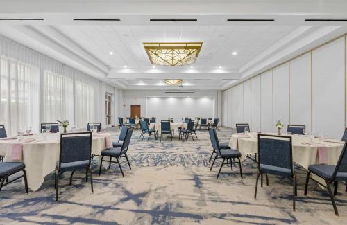 a banquet room with tables and chairs and a chandelier at Hilton Garden Inn Auburn in Auburn