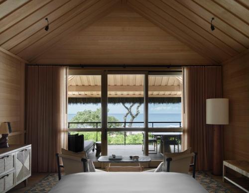 a bedroom with a bed and a large window at Kona Village A Rosewood Resort in Kailua-Kona